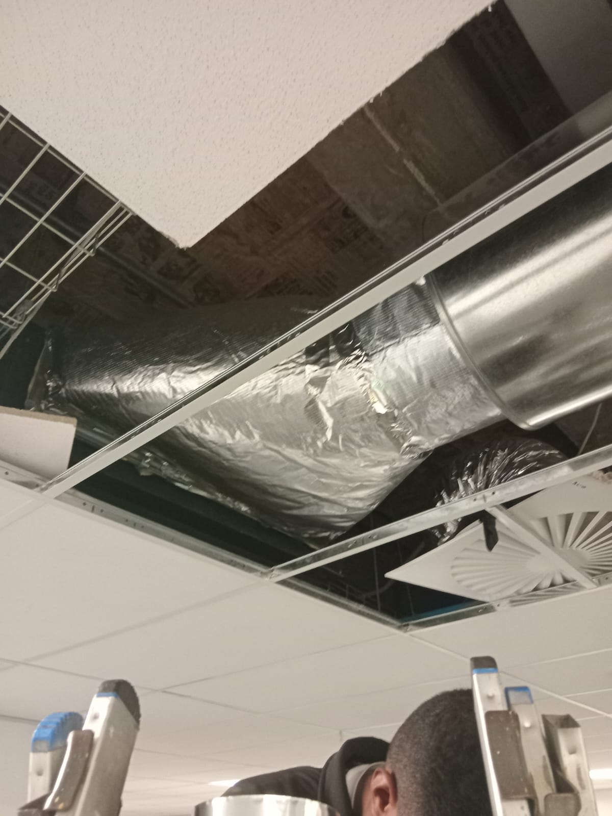 Insulated flexi & spiral ducting into swirl diffuser — office ceiling
